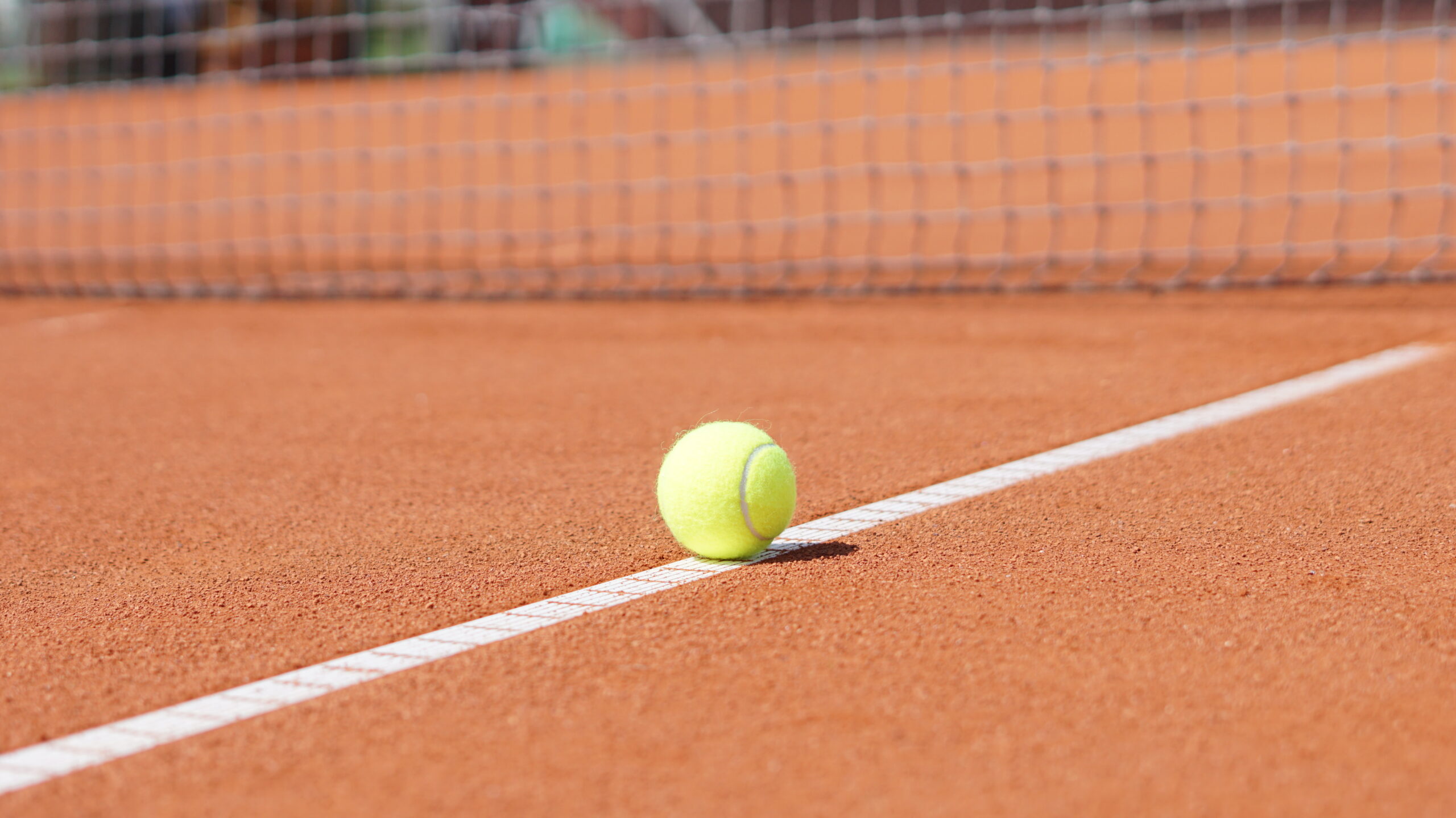 Tennisball auf der Linie eines Sandplatzes