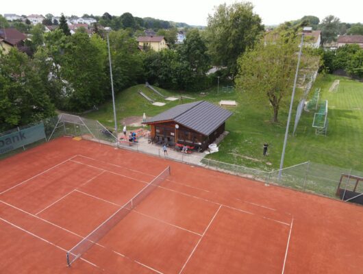 Tennisplatz von oben mit Vereinshaus