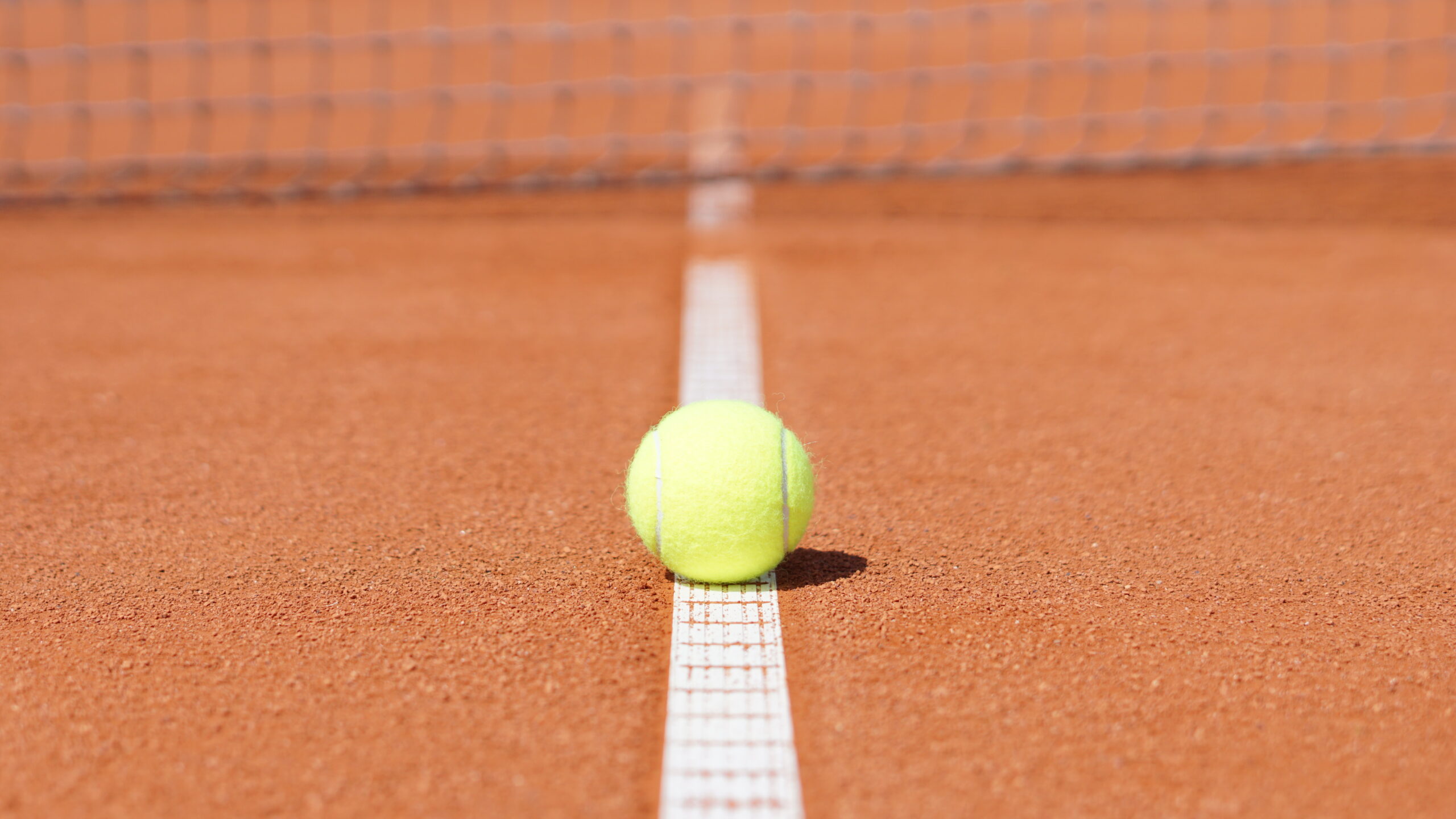 Tennisball auf Linie eines Sandplatzes