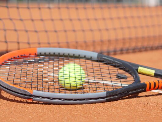 Tennisball mit Schläger auf Feld